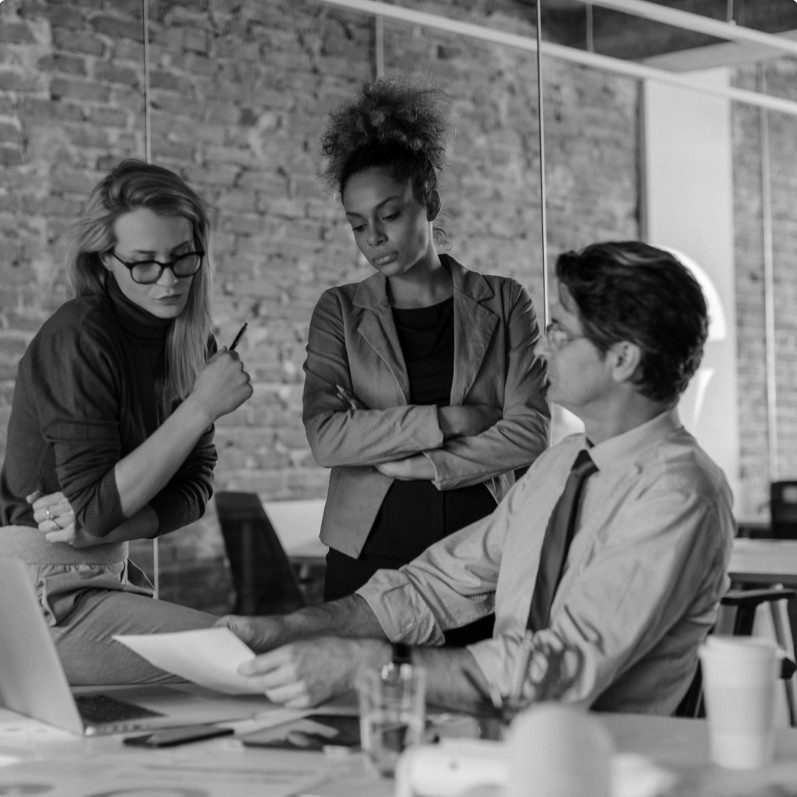 Three colleagues working through a document together at a table